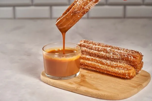 Churros Caseiros Deliciosos e Fácil de Fazer. Aprenda Agora 3 churros com uma vasilha de doce de leite