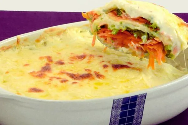 Lasanha de Brócolis e Cenoura com Molho Branco Cremoso uma colher tirando pedaço de lasanha